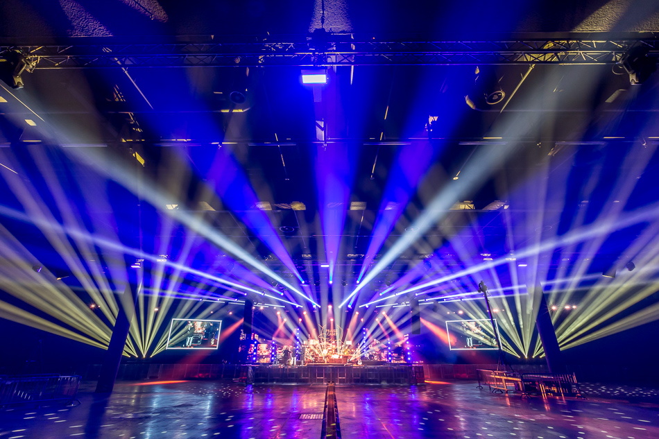PraiseCamp: Messehalle mit Traversen, Lichtstrahlen und Videoleinwänden